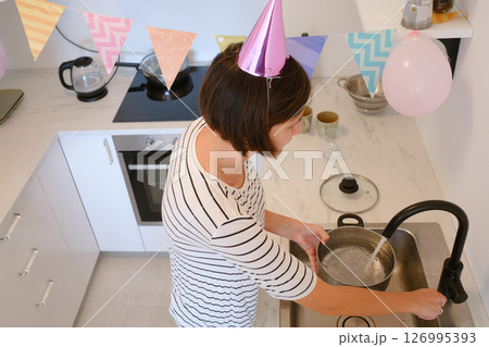 Young woman celebrates her birthday at home, surrounded by cozy atmosphere and festive decorations. She cooking a festive dinner, delicious pasta Young woman celebrates her birthday at home, surrounded by cozy atmosphere and festive decorations. She cooking a festive dinner, delicious pasta 126995393