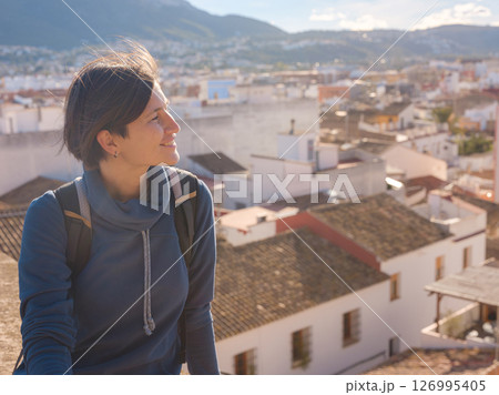 Young woman exploring historic castle in Denia, Alicante province, Spain, scenic views of town below, set against cooler season backdrop. blend of history and tranquility in timeless setting. Young woman exploring historic castle in Denia, Alicante province, Spain, scenic views of town below, set against cooler season backdrop. blend of history and tranquility in timeless setting. 126995405