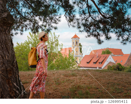 Beautiful woman walking of Varazdin streets during summer day in old, historical city center. Tourist exploring the beautiful streets, view on city from fortess 126995411