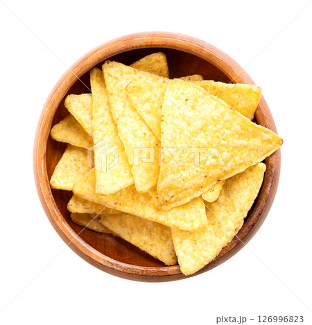Tortilla chips in a wooden bowl. Classic, crunchy snack food, made from corn tortillas, cut into triangle shaped wedges, fried in oil, and slightly salted. Close-up, from above, isolated, food photo. Tortilla chips in a wooden bowl. Classic, crunchy snack food, made from corn tortillas, cut into triangle shaped wedges, fried in oil, and slightly salted. Close-up, from above, isolated, food photo. 126996823