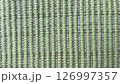Textured green woven fabric displayed in close-up view 126997357