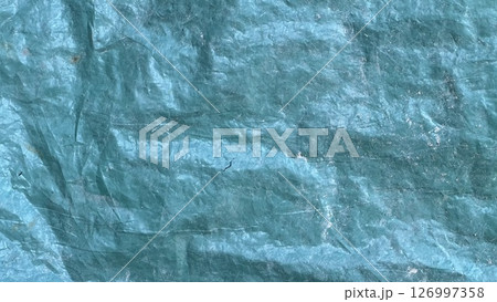 Textured blue tarp surface showing creases and color variations 126997358