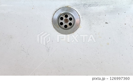 Water drain on a white surface showing signs of wear and dirt 126997360