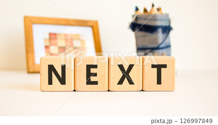 Next symbol. Concept word Next on beautiful wooden blocks. Beautiful picture frame and colored pencils. Beautiful white table white background. Business, lifestyle, support next concept. Copy space. Next symbol. Concept word Next on beautiful wooden blocks. Beautiful picture frame and colored pencils. Beautiful white table white background. Business, lifestyle, support next concept. Copy space. 126997849