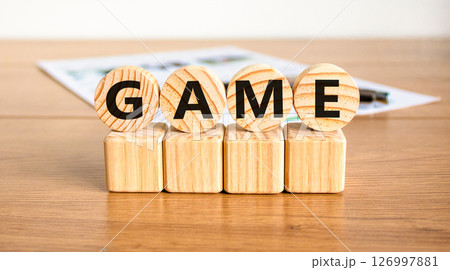 Game symbol. Concept word Game on beautiful wooden circles on wooden blocks. Beautiful wooden table white background. Business, lifestyle and game concept. Copy space. 126997881