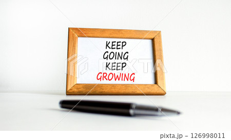 Keep going and growing symbol. Concept words phrase Keep going keep growing on beautiful wooden picture frame. Beautiful white background. Business Keep going and growing concept. Copy space. Keep going and growing symbol. Concept words phrase Keep going keep growing on beautiful wooden picture frame. Beautiful white background. Business Keep going and growing concept. Copy space. 126998011