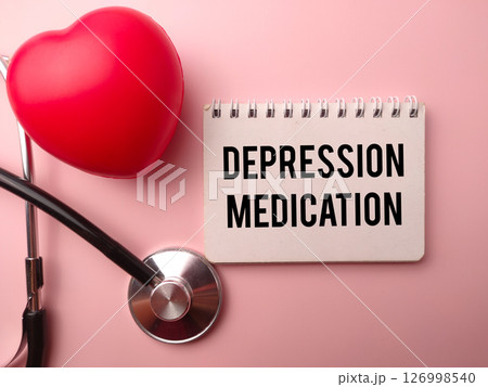 Red heart shape and statehoscope with the word DEPRESSION MEDICATION on a pink background. Red heart shape and statehoscope with the word DEPRESSION MEDICATION on a pink background. 126998540