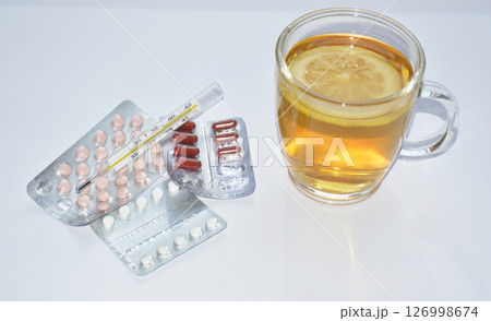 pills, thermometer and tea with lemon on white background 126998674