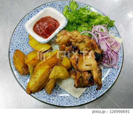 chicken shashlik with potato wedges and ketchup chicken shashlik with potato wedges and ketchup 126998691