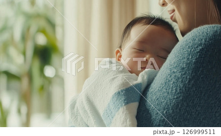 Newborn asian baby sleeping in mothers arms, intimate family moment 126999511