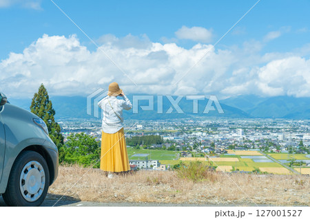スマホで撮影　車でドライブ旅行中の女性　車と女性 127001527