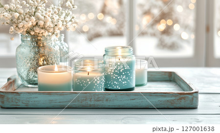 Winter decor in blue and white with burning candles and flowers on wooden tray 127001638