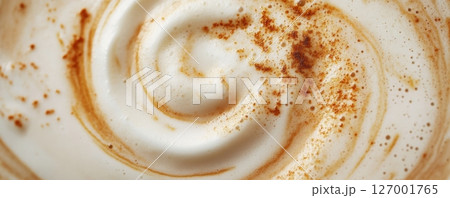 Close-up of frothy coffee with cinnamon swirl, textured surface. Warm beverage and autumn concept 127001765