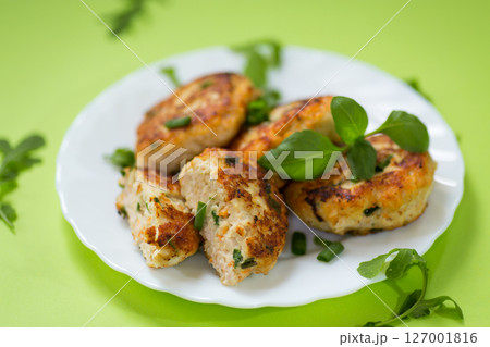 Homemade chicken cutlets on a plate isolated on a green background Homemade chicken cutlets on a plate isolated on a green background 127001816