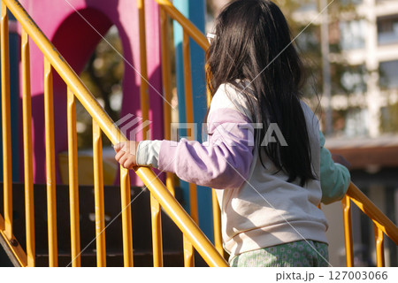 Child climbing stairs at playground during sunny afternoon Child climbing stairs at playground during sunny afternoon 127003066