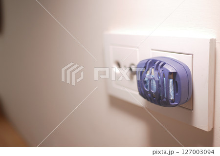 an electric mosquito repellent plugged into a wall socket an electric mosquito repellent plugged into a wall socket 127003094