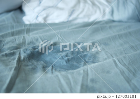 Bed sheet with stain on blue fabric during daytime 127003181
