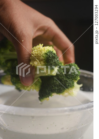 Washing fresh broccoli in a kitchen sink Washing fresh broccoli in a kitchen sink 127003294