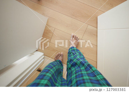 Walking barefoot on wooden floor in cozy pajamas Walking barefoot on wooden floor in cozy pajamas 127003381