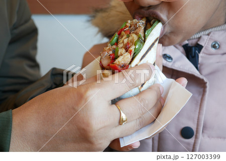 Enjoying a tasty sandwich in a cozy cafe setting Enjoying a tasty sandwich in a cozy cafe setting 127003399