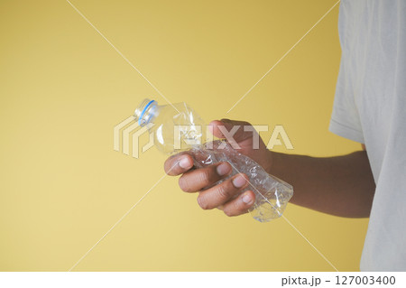Crumpled bottle on yellow background 127003400