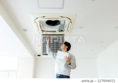 オフィスのエアコンを修理する男性 127004015