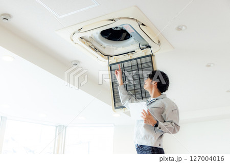 オフィスのエアコンを修理する男性 オフィスのエアコンを修理する男性 127004016