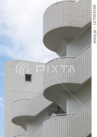 白いタイル張りのアパートの階段と四角い小窓 127004288