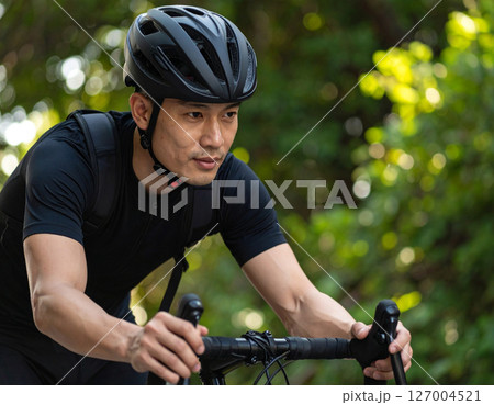 ヘルメット被って自転車に乗る男性 127004521