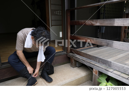 庭で足袋を履く庭師などの外仕事の男性 庭で足袋を履く庭師などの外仕事の男性 127005553