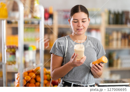 Woman choosing sauce in the store Woman choosing sauce in the store 127006695