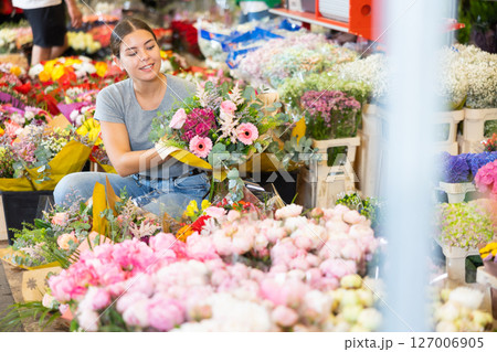 Female shopper chooses a chic bouquet of flowers at flower market 127006905
