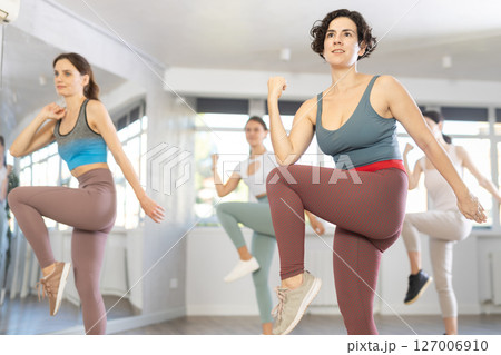 Slender young women dancers dance twist in modern way Slender young women dancers dance twist in modern way 127006910