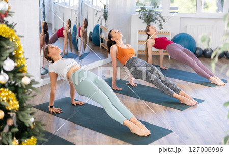 Young female yoga instructor guiding group class at Christmastime 127006996