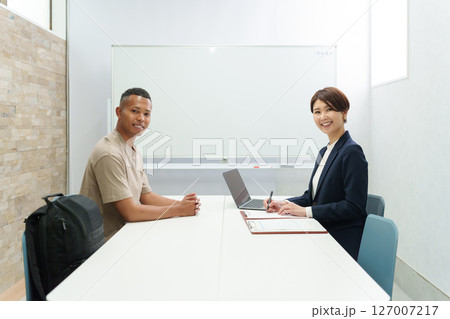 手続きをする外国人労働者とスタッフ 127007217