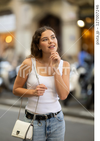 Young girl enjoying walk along summer city stree 127007246