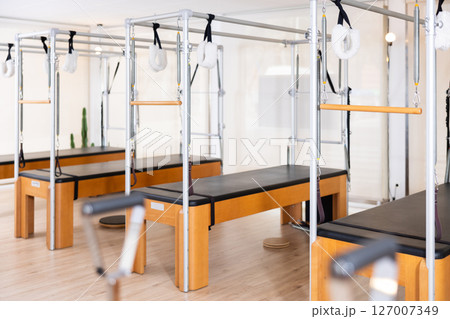 Interior of modern Pilates studio with trapeze tables for exercises 127007349