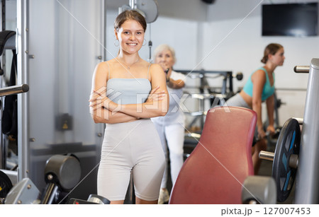 Portrait of slim woman smiling after work out in gym Portrait of slim woman smiling after work out in gym 127007453