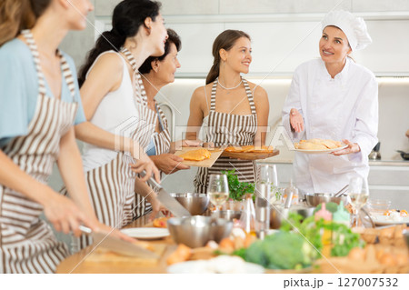 Girl chef tell group of students listeners cooking courses about secrets of cooking juicy chicken 127007532