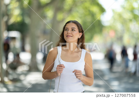 Young smiling girl walks along city street 127007558
