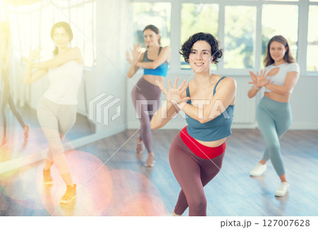 Female teacher conducts modern dance lessons for group of girls 127007628