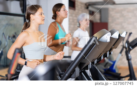 Girl in sportswear are running on treadmill 127007745