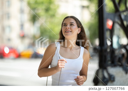 Young smiling girl walks along city street 127007766