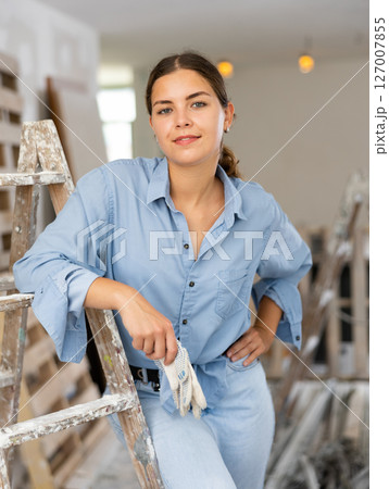 Pretty cottage owner posing in room being renovated Pretty cottage owner posing in room being renovated 127007855