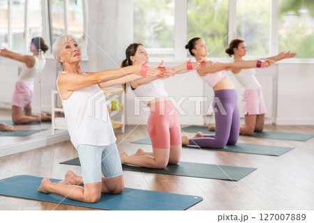 Elderly woman exercises with pilates band 127007889