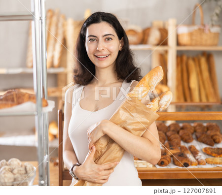Young woman buying baguettes in bakery 127007891