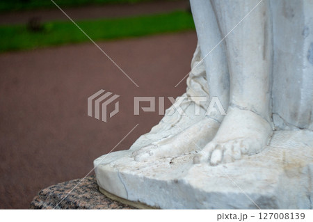 Marble statue close-up of elegant feet in park setting 127008139
