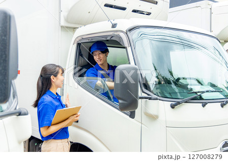トラックのドライバーと打ち合わせをする配送スタッフ 127008279