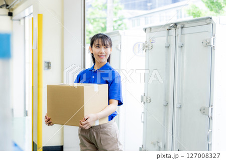 荷物を届ける宅配便の女性ドライバー 127008327