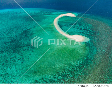 Tropical landscape with white sand bar surrounded by greenish ocean water and coral reefs. White Island. Camiguin, Philippines. Tropical landscape with white sand bar surrounded by greenish ocean water and coral reefs. White Island. Camiguin, Philippines. 127008560